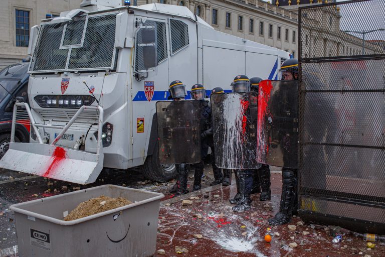 Manifestation contre la réforme des retraites, 1er mai 2023. Le ton monte encore d&rsquo;un cran jusqu&rsquo;au devenu traditionnel mur de grilles et les  canons à eau à l&rsquo;entrée de Bellecour où se joue une bataille toujours aussi étrange, jet de pierres contre canon a eau et jet d&rsquo;eau jusqu&rsquo;à épuisemment.
